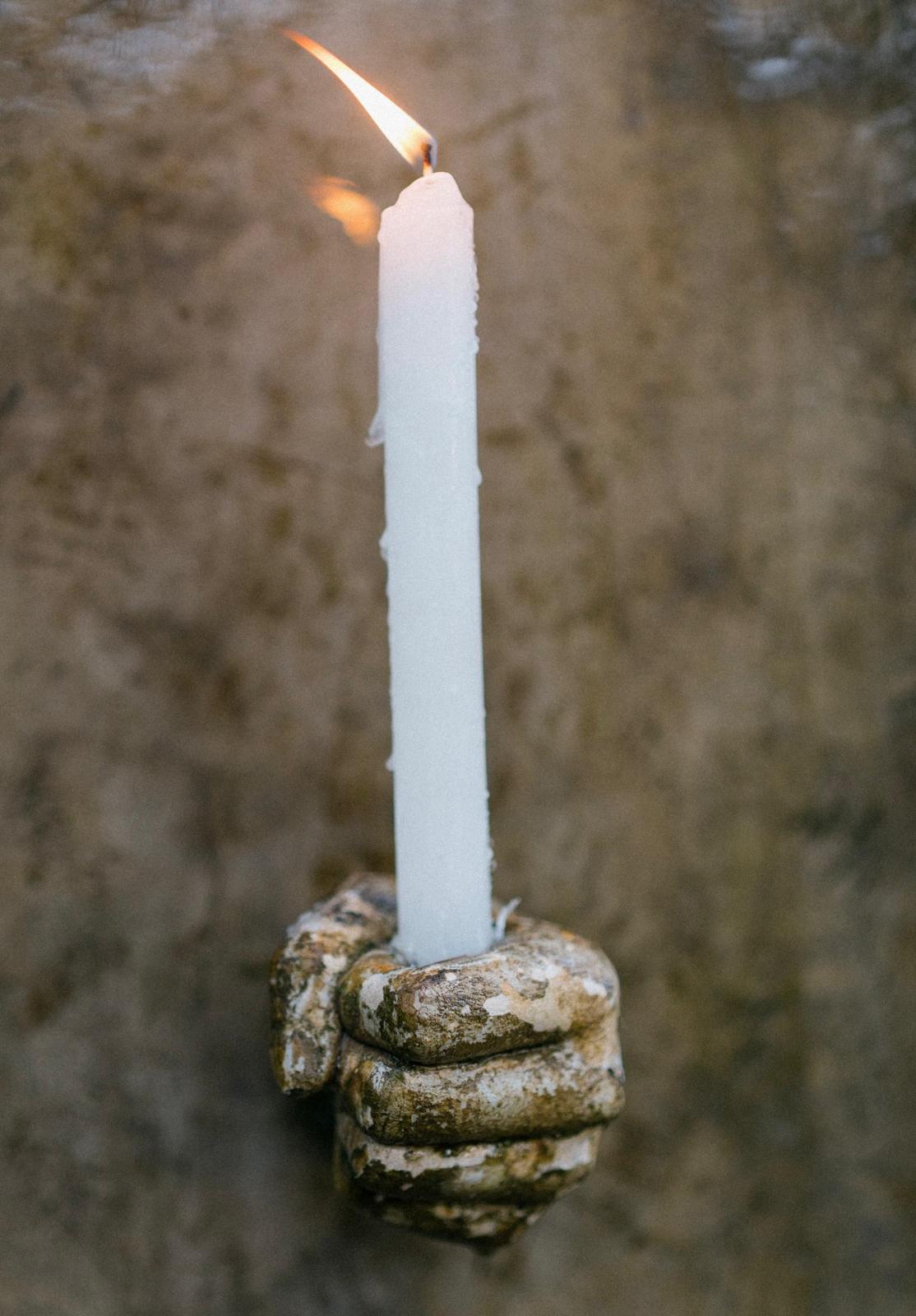 Ofrendas — hand holding candle